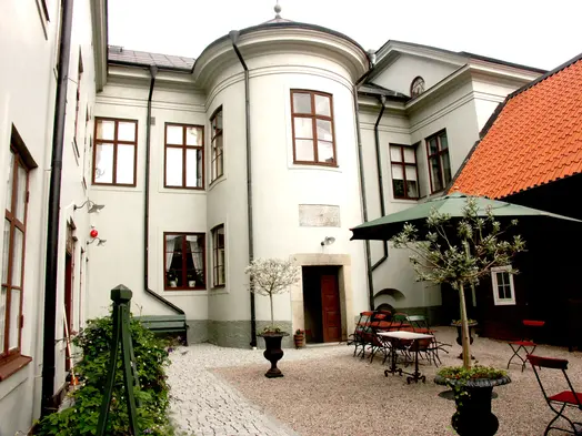 Arboga museums innergård med trädgårdsbord och parasoll.